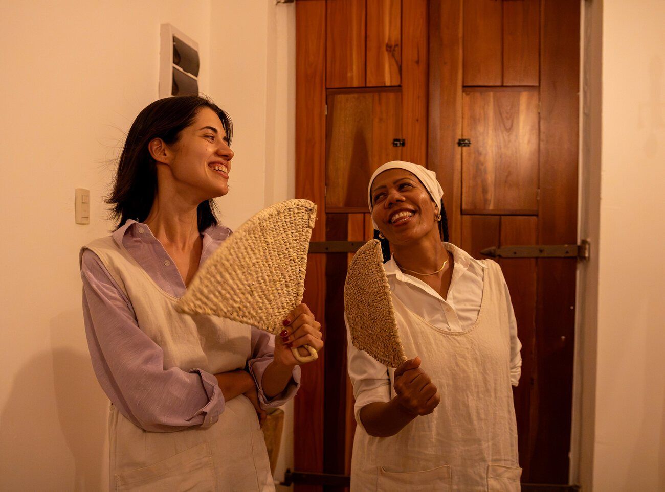 Giulia y Maribel sonríen con abanicos tejidos